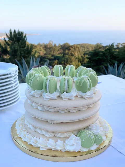 A celebration cake decorated with green macarons